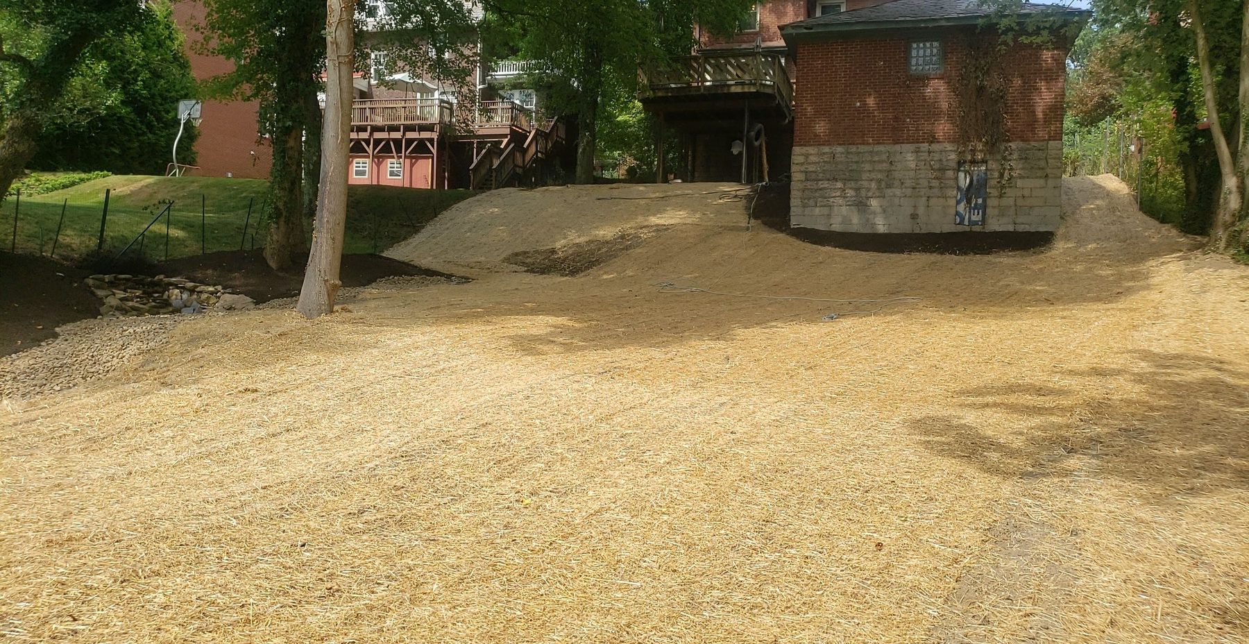 A regraded back yard seeded and covered in straw